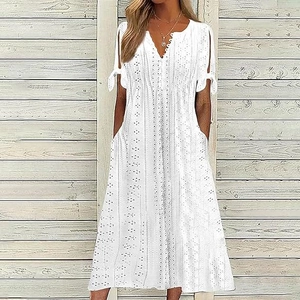 Detail of V-neck buttoned bodice with delicate eyelet embroidery on a white dress