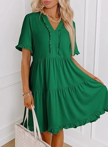 Detail of green tiered mini dress featuring ruffled V-neck and layered ruffle sleeves