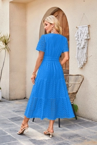 Dettaglio di abito blu con scollo a V, ricamo a occhiello e gonna a balze bohémien