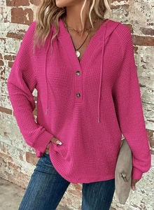 Detail of rose pink waffle knit hoodie featuring a V-neck with buttons and drawstrings