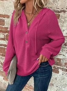 Detail of waffle knit fabric texture and V-neck button placket on rose red hoodie