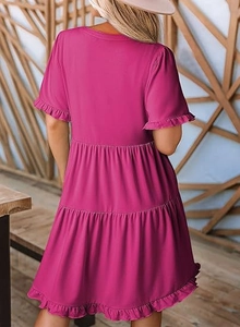 Detail view of the elegant magenta tiered dress showing ruffled sleeves and hemline