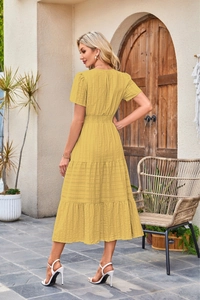 Detailed back view of a yellow tiered midi dress with elastic waist and striped texture