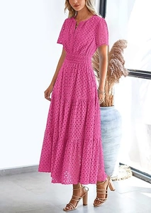 Dettaglio dell'abito lungo in pizzo rosa con scollo a V e gonna a balze a strati