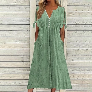 Detailed view of sage green eyelet embroidery fabric and white buttons on V-neck dress
