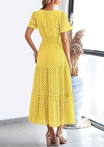 Dettaglio dell'abito giallo ricamato con gonna a balze e vista della silhouette posteriore