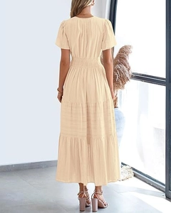 Detailed back view of a beige tiered dress with V-neckline and puff short sleeves