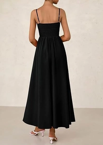 Detail view of the smocked back design and thin straps on a black maxi dress