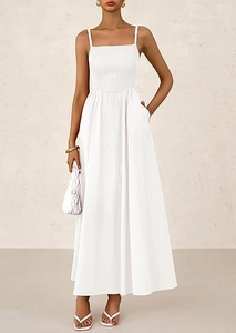 Detail of white smocked bodice and thin straps on a flowing summer maxi dress