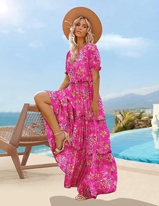 Detail of fuchsia floral maxi dress with puff sleeves and tiered skirt in a resort setting
