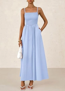 Detail of light blue smocked sundress featuring delicate straps and side pockets