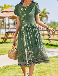 Detail of dark green floral A-line dress with petal sleeves on sunny outdoor lawn