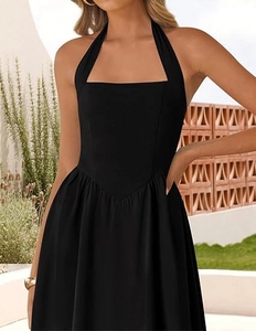 Close-up of black halter neck dress featuring an elegant square neckline and pleated waist