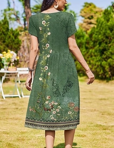 Close-up of ethnic floral vine pattern on dark green short sleeve midi dress back