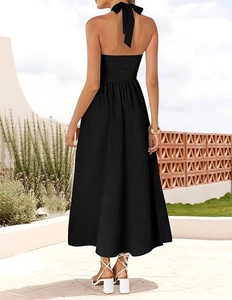 Detail of elegant black halter dress featuring a smocked back and back bow tie detail