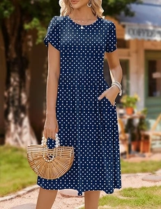 Detail shot of navy blue polka dot dress featuring a high waist and side pockets