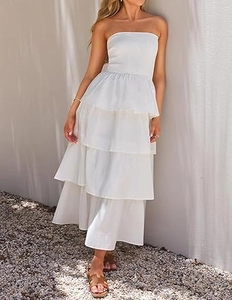 Detailed view of layered tiered skirt of white strapless maxi dress in sunlight