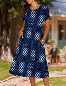 Close-up of the navy blue polka dot dress featuring a high waist and side pockets