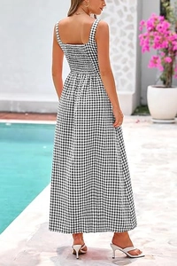 Back view of a black and white gingham maxi dress with ruched detail by a sunny pool