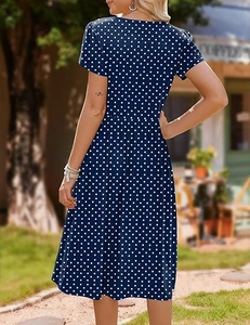 Rear view of a dark blue short sleeve dress with white polka dots and a cinched waist design