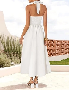 Detail of white halter neck dress featuring smocked elastic back and large bow tie
