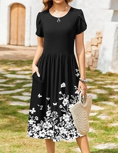 Detail of floral butterfly print on a black midi dress featuring practical side pockets