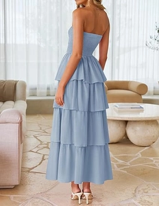 Detail view of the tiered cake skirt design and smocked bodice on the light blue maxi dress