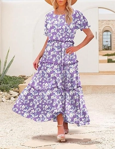 Detail of tiered purple floral dress with puff sleeves and ruffled hem for summer wear