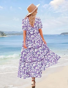 Back view of a purple floral tiered maxi dress with tiered ruffles on a sunny beach
