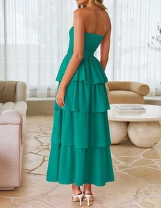 Detail of emerald green smocked bodice and layered tiered maxi dress fabric texture