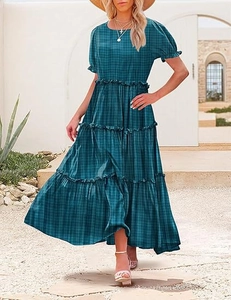 Close-up of the tiered skirt hem and dark green plaid fabric on this maxi dress