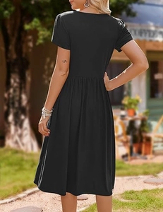 Back view of a black mid-length dress with petal sleeves and pleated skirt in sunlight