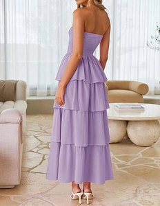 Detail of tiered ruffled layers and smocked bodice on a purple strapless maxi dress