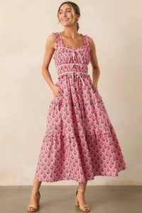 Detailed close-up of pink floral dress featuring ruffled straps and tiered skirt design