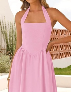 Close-up of pink halter neck dress with pleated V-waistline and flared A-line skirt