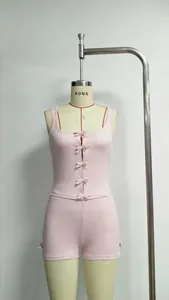 Detail of pink two-piece set featuring front bow accents and square neckline on a tank top