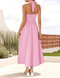 Pink halter dress back view with a large bow tie and smocked elastic details