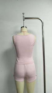 Rear view of a soft pink two-piece ribbed knit set featuring a tank top and elastic shorts
