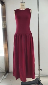 Detail view of burgundy sleeveless maxi dress with pleated skirt on mannequin