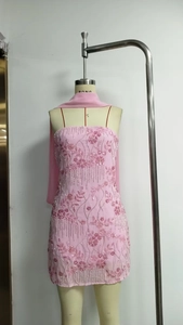 Detail of pink sequin floral embroidery and sheer shawl on a mini party dress