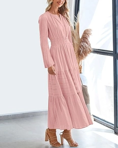 Détail d'une robe longue rose à col en V, taille froncée et jupe à plusieurs niveaux