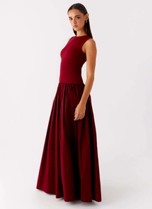 Detail view of burgundy sleeveless dress featuring ribbed knit bodice and pleated skirt