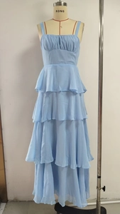 Detail of light blue tiered chiffon dress featuring delicate straps and ruffle layers