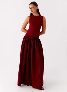 Detail of burgundy sleeveless maxi dress with a drop waist and voluminous pleated skirt