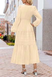 Détail d'une robe longue beige à volants avec taille haute élastique et manches longues