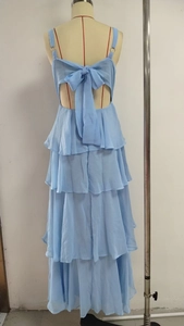 Detail of light blue tiered dress featuring a backless design and oversized bow tie tie-up