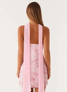 Detailed back view of light pink sequin mini dress featuring long flowing neck ties