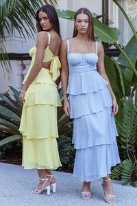 Detail of multi-layered ruffled cake dress featuring elegant back bow tie and light fabric