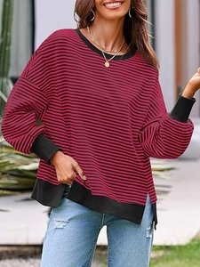 Détail du tricot gaufré et de l'ourlet fendu sur le sweat-shirt à rayures à manches