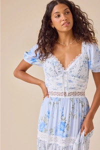 Detail of blue floral dress featuring intricate white lace stitching and V-neckline lace trim